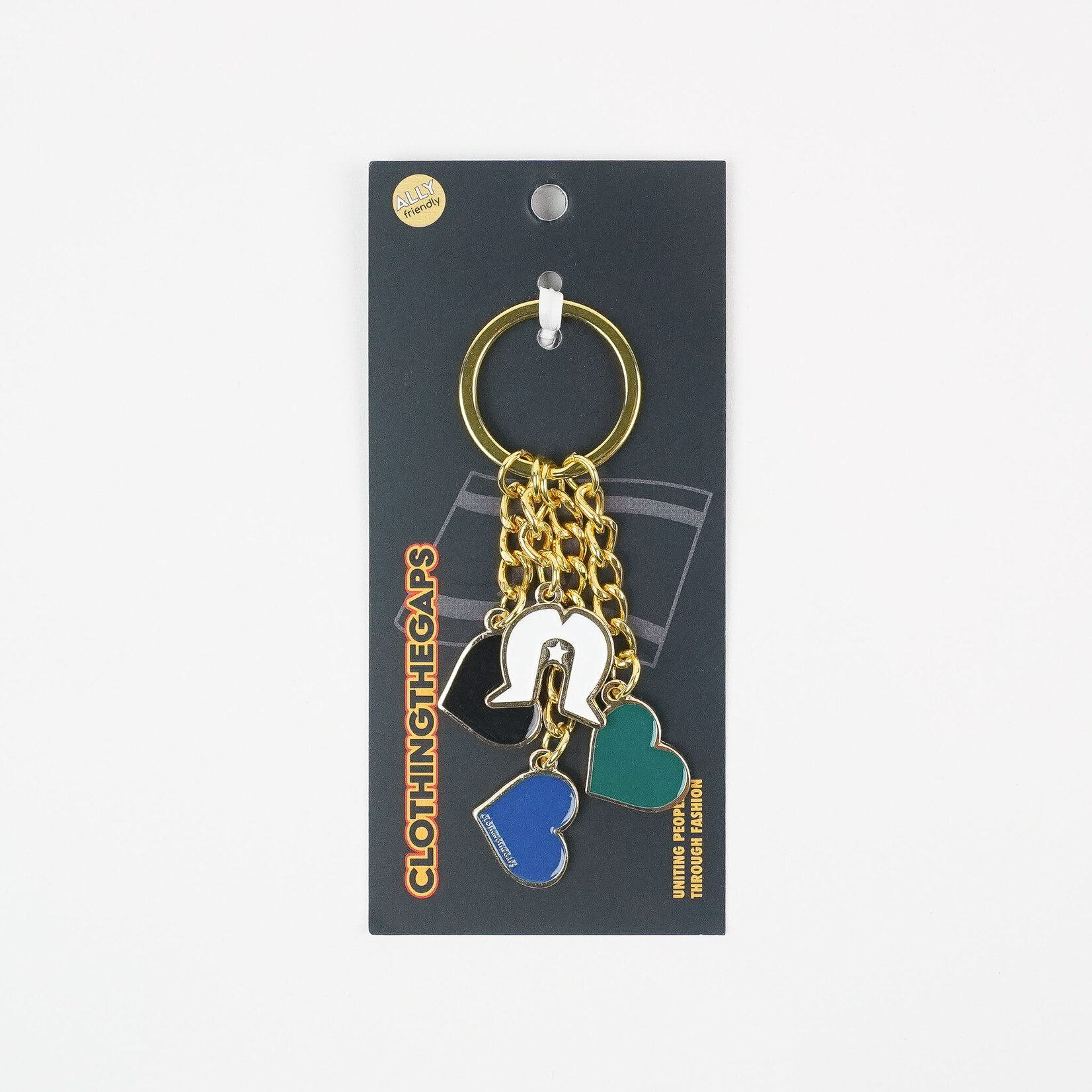 A Clothing The Gaps keyring with enamel heart, helmet and shell charms on a gold chain, packaged on a black card.