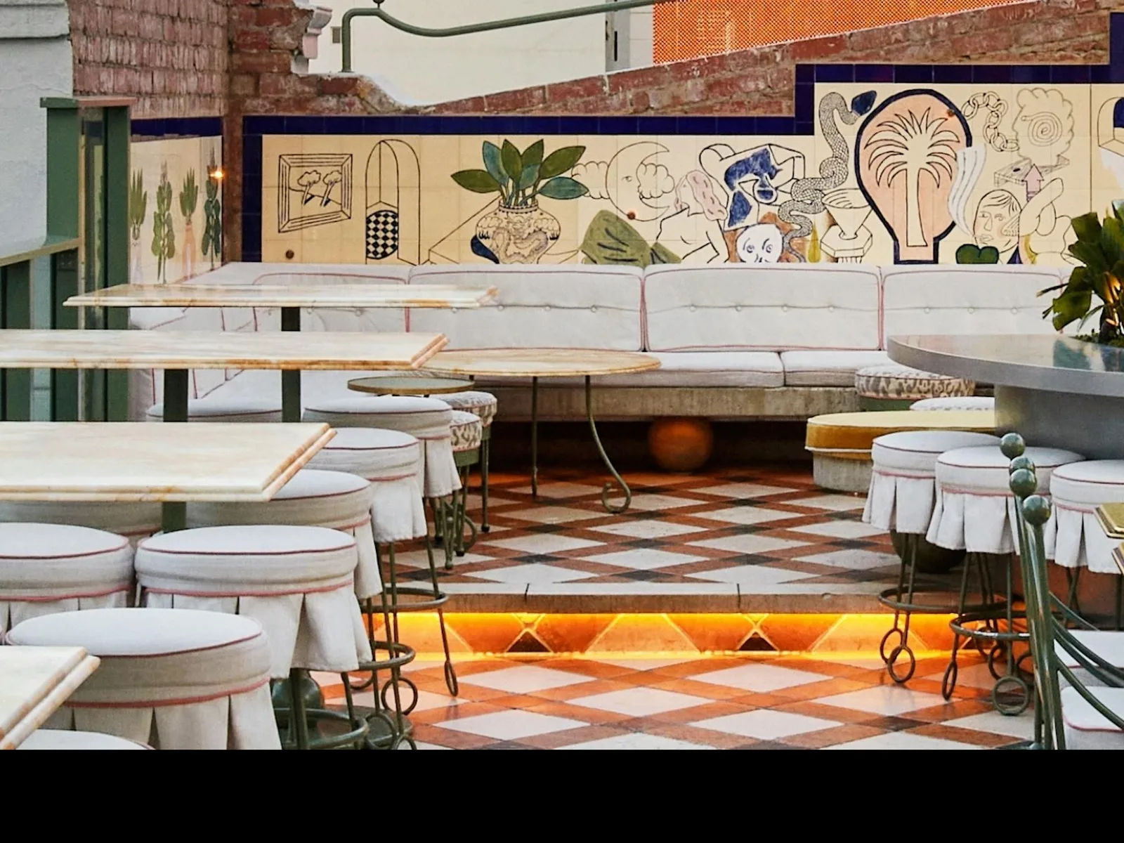 HER rooftop terrace in Melbourne with tiled floor, marble tables and a painted mural wall