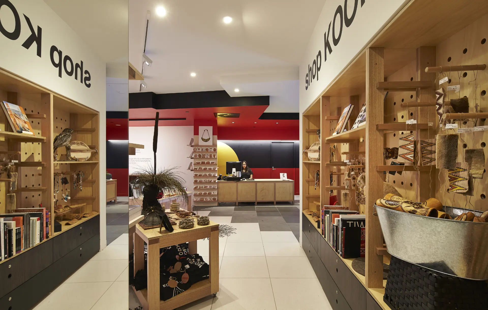 Interior of the Koorie Heritage Trust shop, with timber shelves displaying books, cultural objects, jewellery and gifts.